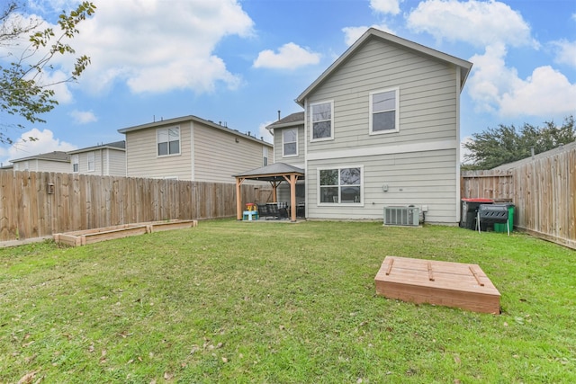 rear view of property featuring a gazebo, central air condition unit, and a lawn