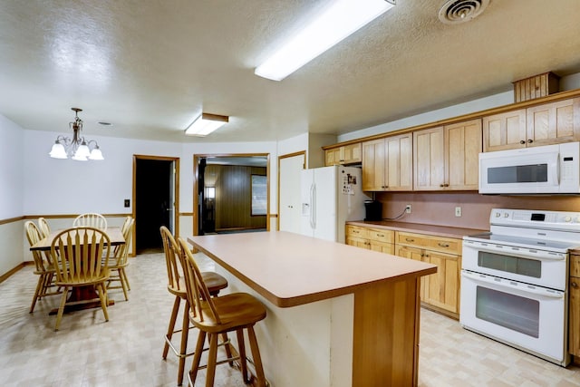 kitchen with white appliances, a textured ceiling, pendant lighting, an inviting chandelier, and a kitchen island