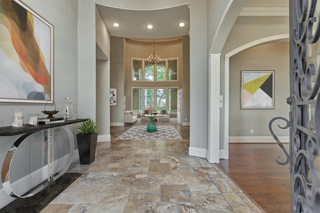 foyer featuring a towering ceiling and a notable chandelier