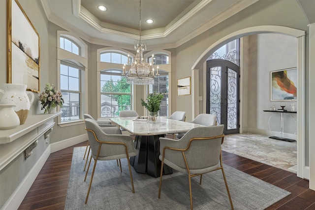 dining area featuring french doors, a raised ceiling, crown molding, a notable chandelier, and dark hardwood / wood-style floors