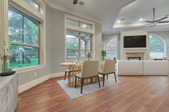 dining space with plenty of natural light, ornamental molding, and dark wood-type flooring