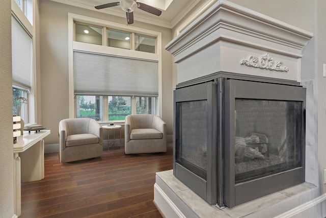 interior space featuring ceiling fan, ornamental molding, a high ceiling, and hardwood / wood-style flooring