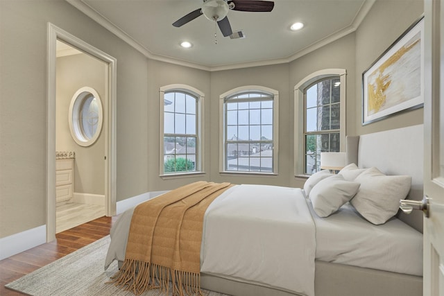 bedroom featuring ceiling fan, wood-type flooring, ensuite bathroom, and ornamental molding