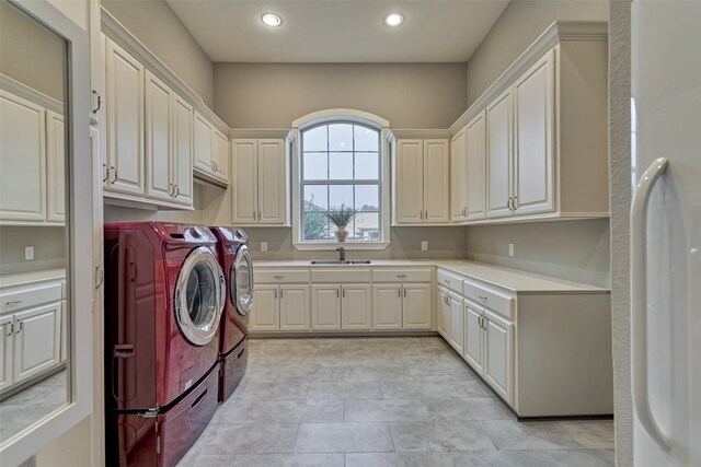 laundry room with washer and clothes dryer, sink, and cabinets