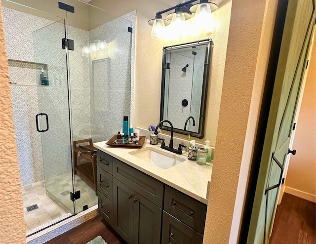 bathroom featuring wood-type flooring, vanity, and walk in shower