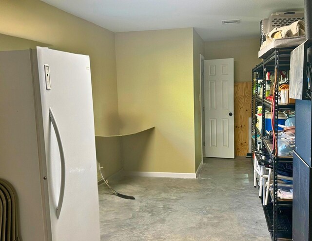 kitchen featuring concrete flooring and white refrigerator