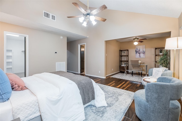 bedroom featuring dark wood-type flooring, high vaulted ceiling, a walk in closet, ceiling fan, and a closet