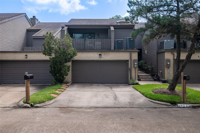 view of front of home with a balcony, a garage, and cooling unit