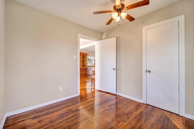 unfurnished bedroom featuring ceiling fan and dark hardwood / wood-style flooring