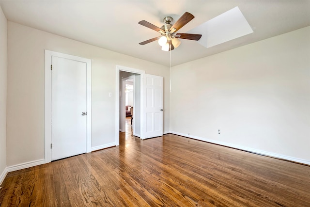 713 Firnat St, Houston, TX 77022 - unfurnished bedroom with a skylight, baseboards, wood finished floors, and a ceiling fan