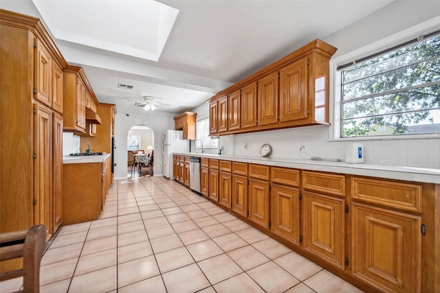 kitchen featuring backsplash, stainless steel dishwasher, ceiling fan, white fridge, and light tile patterned flooring