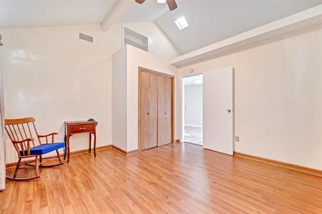 sitting room featuring lofted ceiling with beams, light hardwood / wood-style floors, and ceiling fan