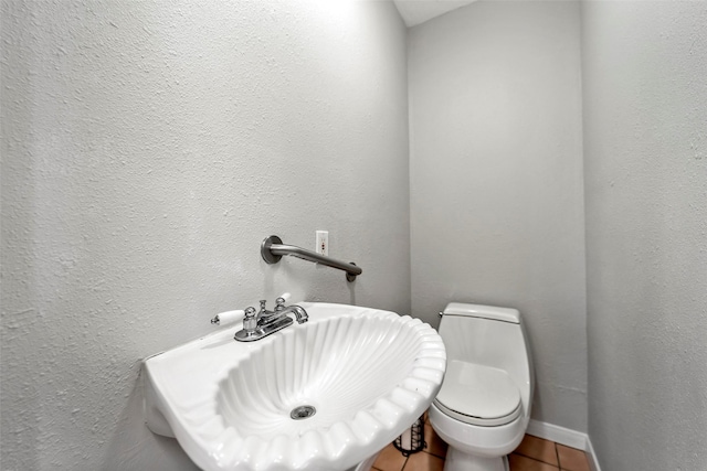 713 Firnat St, Houston, TX 77022 - bathroom featuring toilet, tile patterned flooring, a sink, and baseboards