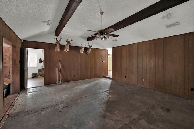 interior space featuring vaulted ceiling with beams, a textured ceiling, and wooden walls