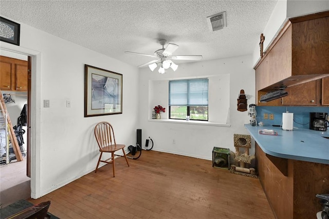 interior space featuring ceiling fan, dark hardwood / wood-style flooring, and a textured ceiling