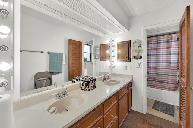 full bathroom featuring shower / bath combo, toilet, a textured ceiling, and vanity