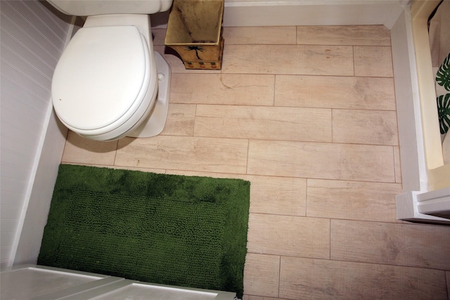 bathroom with wooden walls and toilet