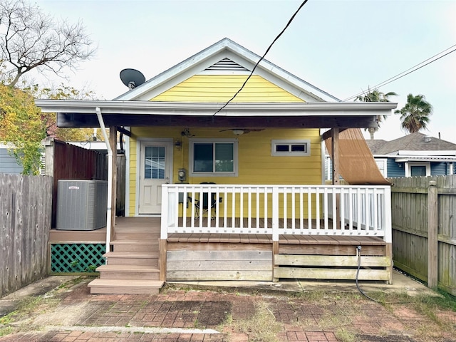 rear view of house featuring cooling unit and covered porch