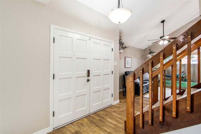 foyer with hardwood / wood-style flooring, vaulted ceiling, and ceiling fan