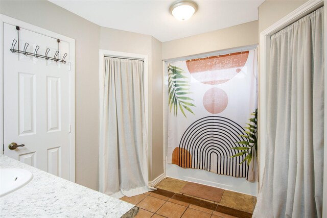 bathroom featuring tile patterned flooring, shower / tub combo, and sink