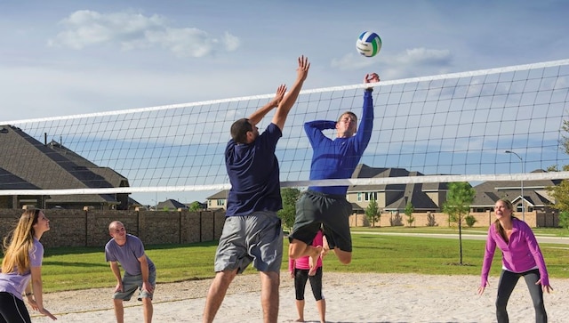 view of community with a lawn and volleyball court