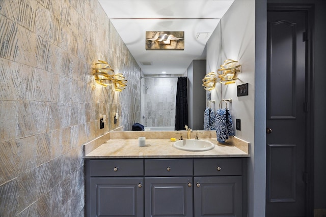 bathroom with a shower with curtain, tile walls, and vanity