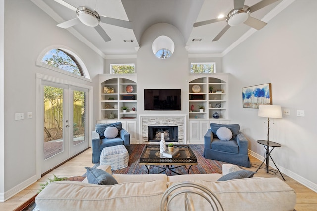 living room with french doors, a healthy amount of sunlight, high vaulted ceiling, and light hardwood / wood-style flooring