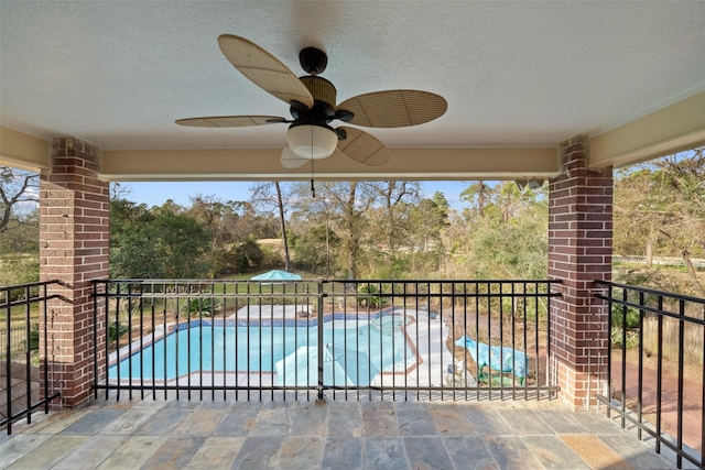 view of swimming pool featuring ceiling fan and a patio area