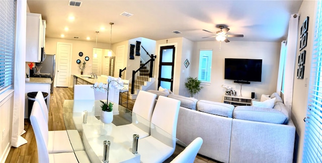 dining room with ceiling fan, light wood-type flooring, and sink