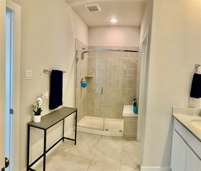 bathroom featuring tile patterned flooring, vanity, and walk in shower