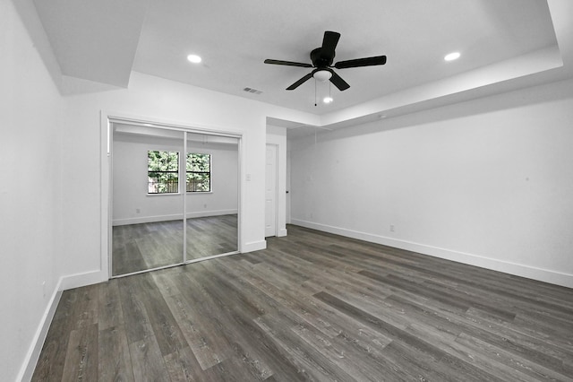 unfurnished bedroom featuring ceiling fan, a closet, and dark wood-type flooring