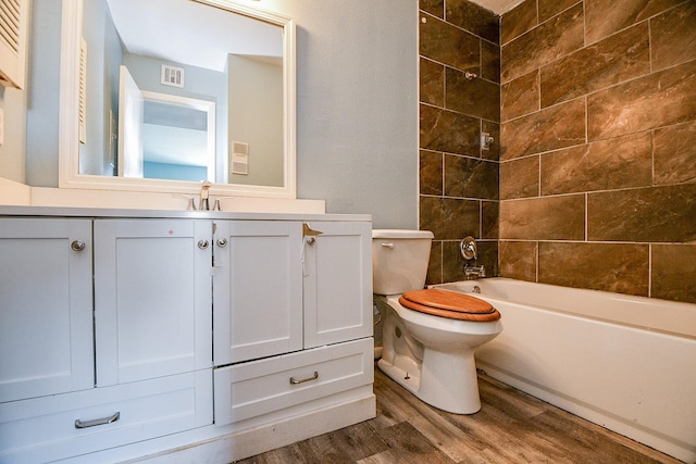 full bathroom with hardwood / wood-style floors, vanity, toilet, and tiled shower / bath