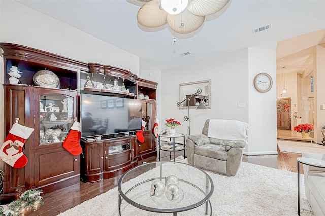 living room with dark hardwood / wood-style floors and ceiling fan