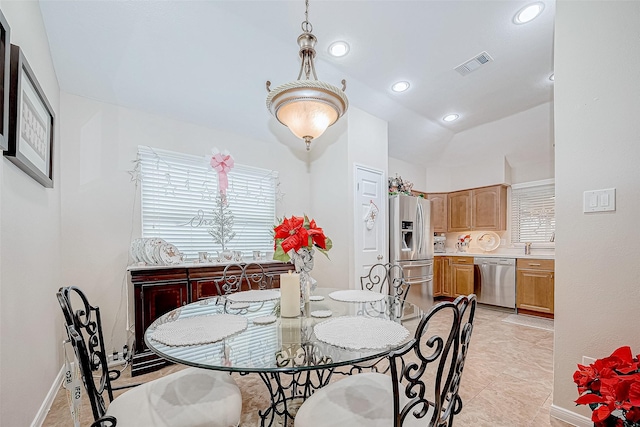 dining room with light tile patterned flooring and vaulted ceiling