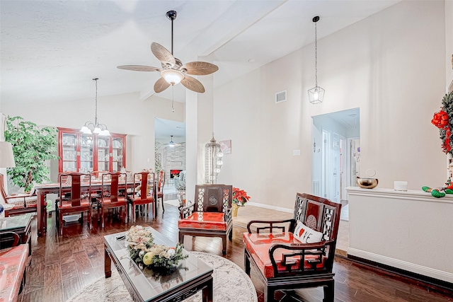 living room featuring ceiling fan with notable chandelier, high vaulted ceiling, and dark wood-type flooring