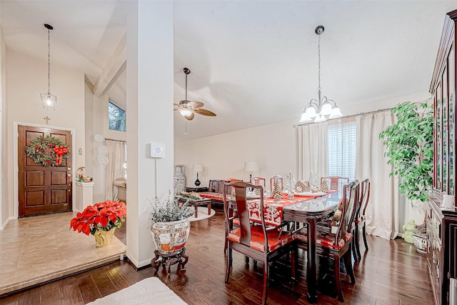 dining area with ceiling fan with notable chandelier, dark hardwood / wood-style flooring, and high vaulted ceiling