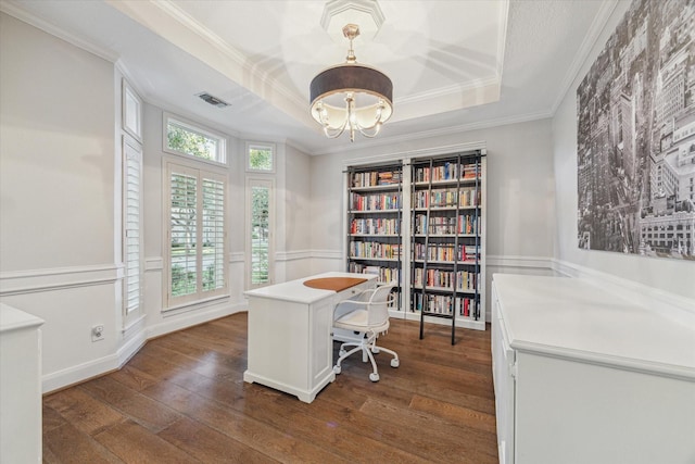 home office with a chandelier, dark hardwood / wood-style flooring, ornamental molding, and a tray ceiling