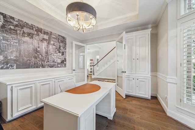 dining space featuring dark hardwood / wood-style flooring, a tray ceiling, an inviting chandelier, and a wealth of natural light