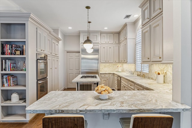 kitchen featuring decorative light fixtures, kitchen peninsula, a breakfast bar area, and stainless steel appliances