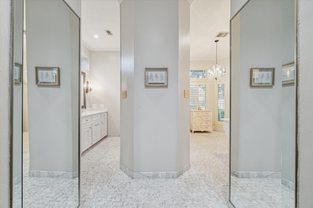 bathroom featuring tile patterned floors, vanity, crown molding, and an inviting chandelier