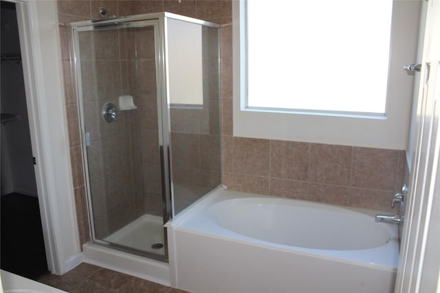 bathroom featuring tile patterned floors, a healthy amount of sunlight, and separate shower and tub