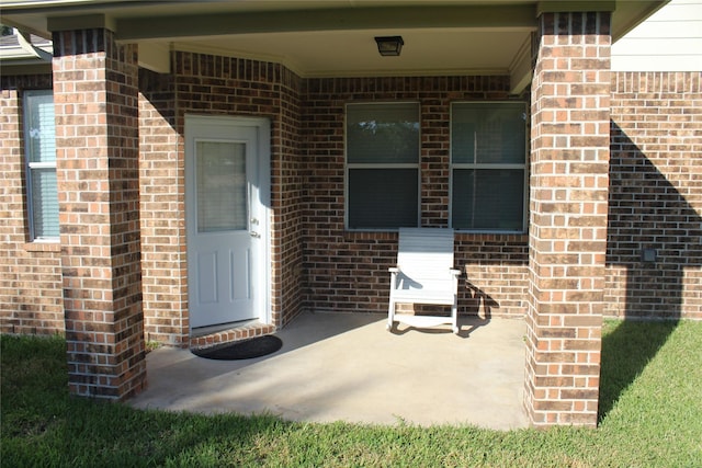 view of exterior entry with a patio area