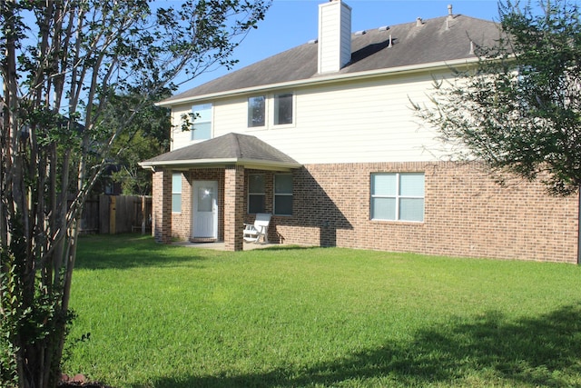 rear view of property with a yard