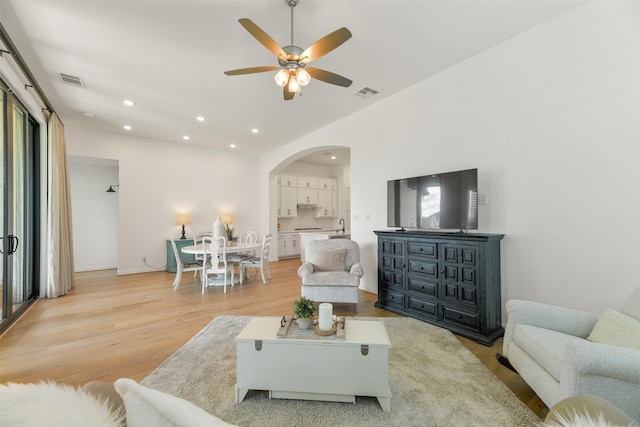 living room featuring light hardwood / wood-style flooring and ceiling fan