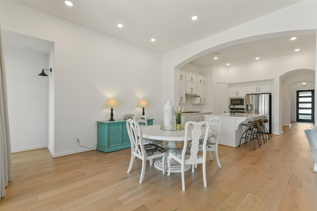 dining area featuring sink and light wood-type flooring