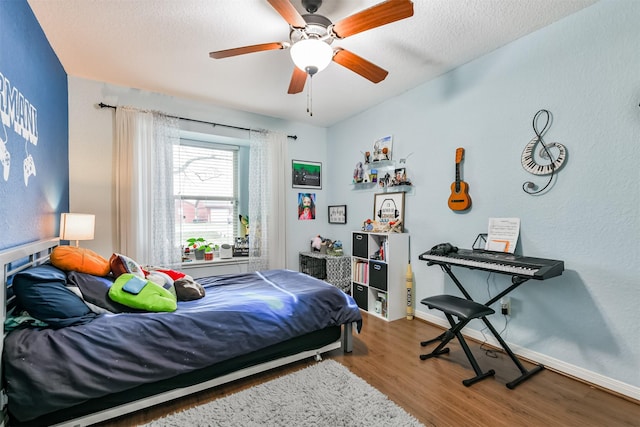 bedroom with wood-type flooring, a textured ceiling, and ceiling fan