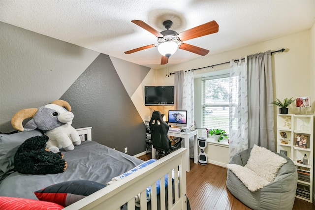 bedroom featuring ceiling fan, dark hardwood / wood-style floors, and a textured ceiling