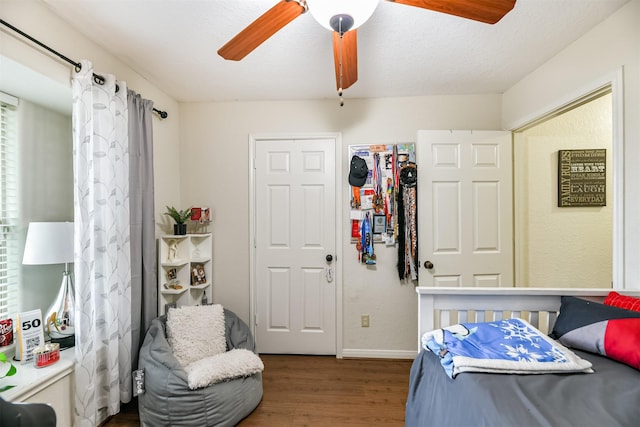 bedroom featuring hardwood / wood-style flooring, ceiling fan, and a textured ceiling