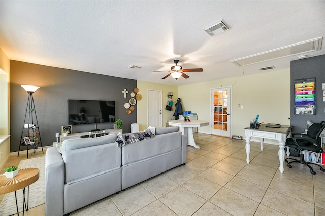 living room featuring light tile patterned floors, a textured ceiling, and ceiling fan