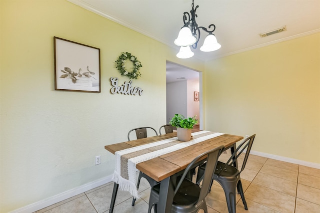 tiled dining space with an inviting chandelier and ornamental molding